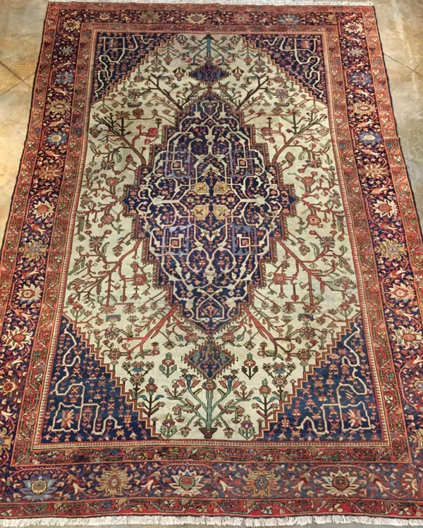 Ornate Persian rug with a central medallion in blue on a cream background